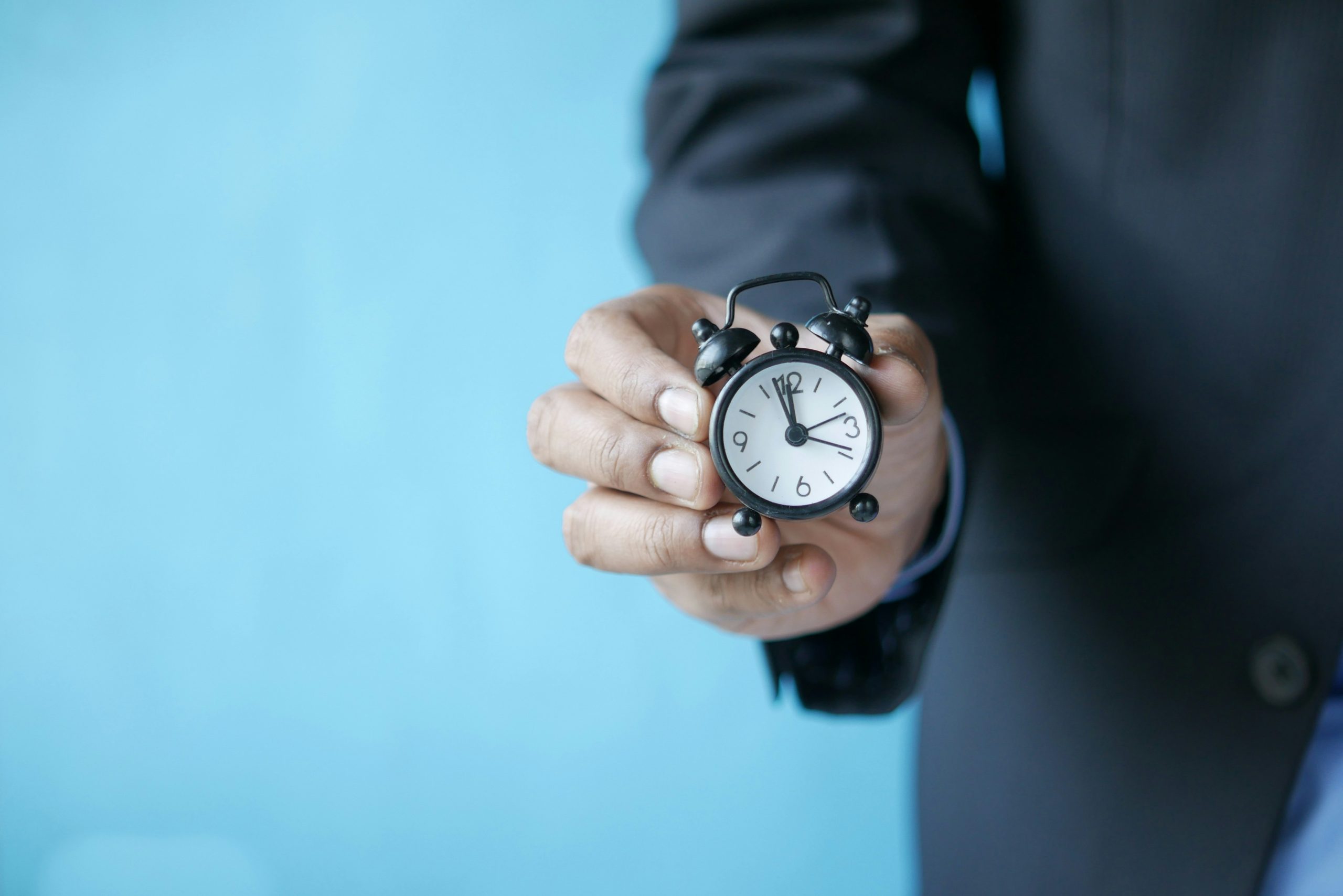 businessman holding a miniature clock